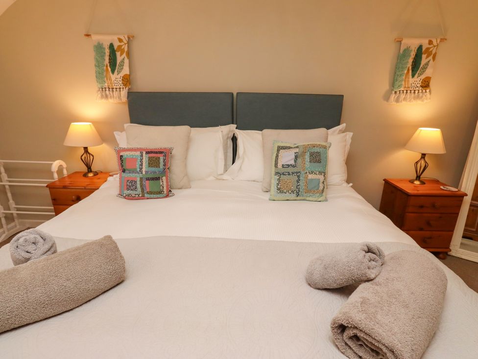 A bedroom with a bed and bedside table at Coble Cottage Craster