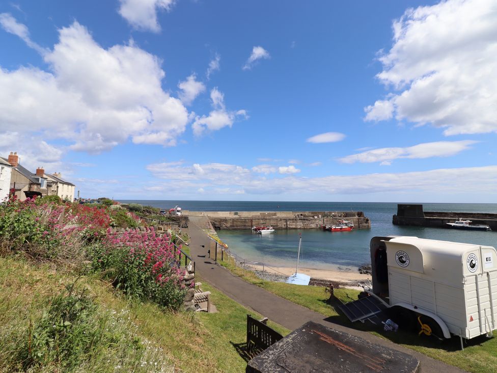 A coastal view with houses and boats at Coble Cottage in Craster