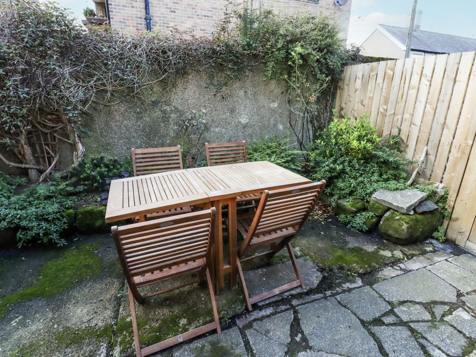 A garden with a wooden table and chairs at Percy Cottages No4 in Alnmouth