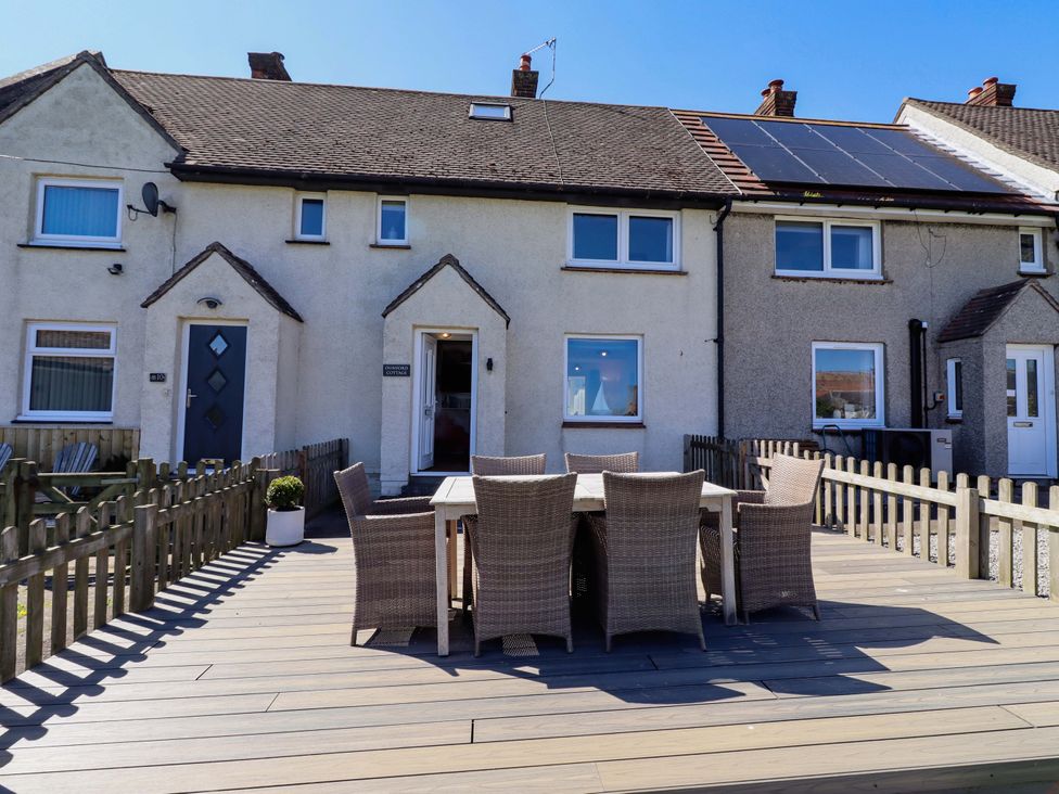 An outdoor seating area with table and chairs at Dunford Cottage in Bamburgh