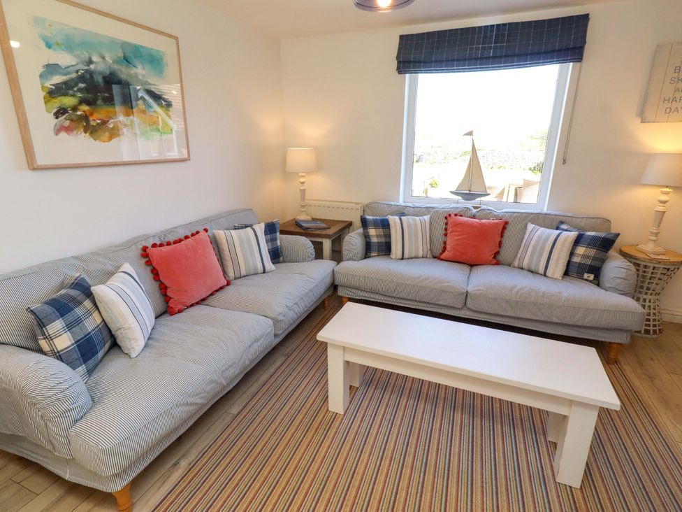 A living room with sofas, a table and a lamp at Dunford Cottage in Bamburgh