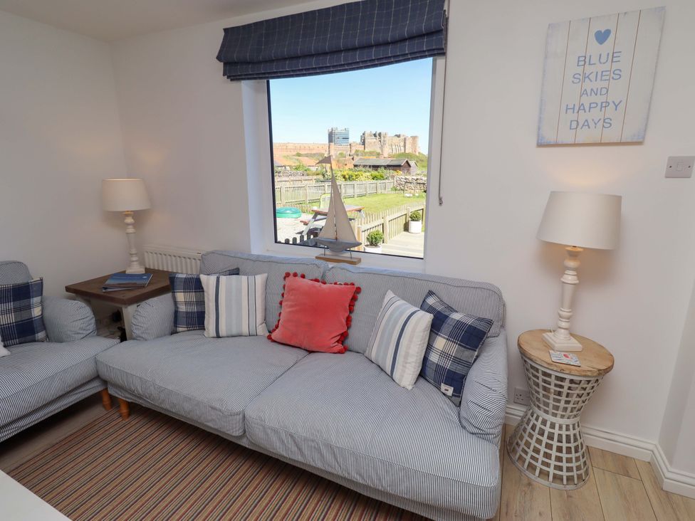 A living room with a sofa and wall art at Dunford Cottage in Bamburgh