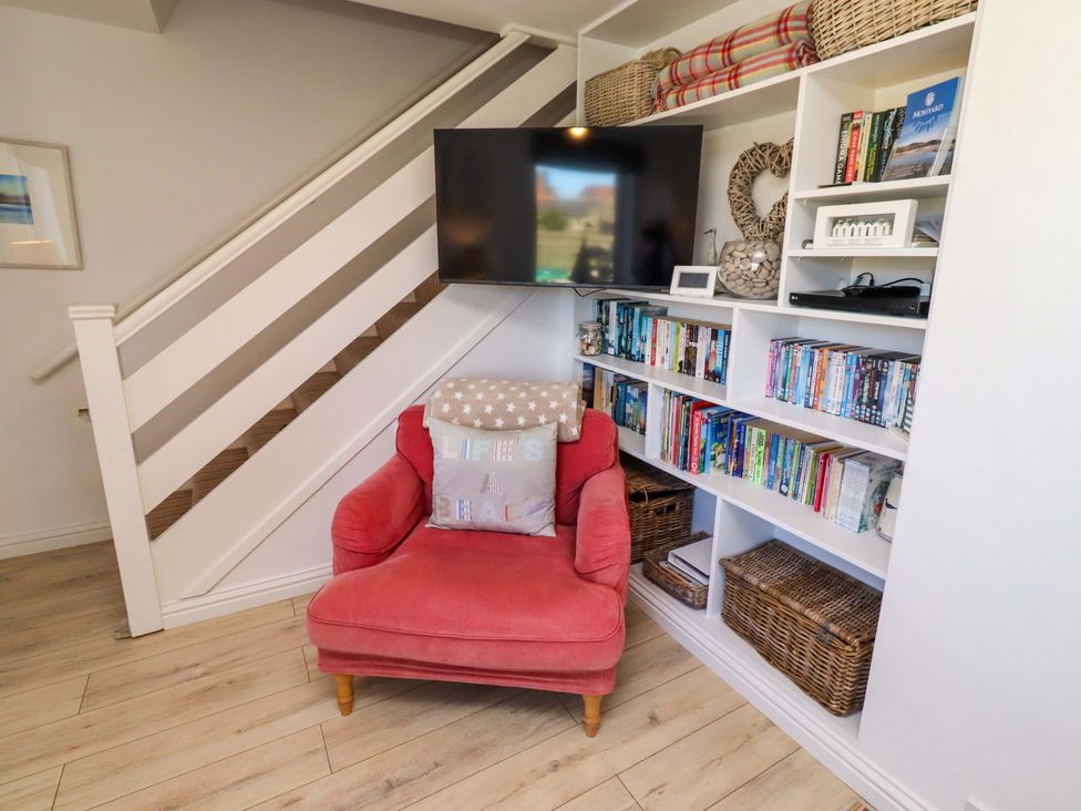 A snug with an armchair and a television at Dunford Cottage in Bamburgh
