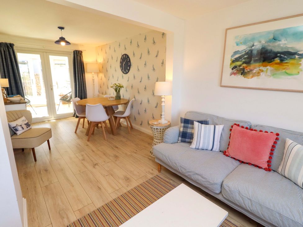 A living room with a sofa and dining area at Dunford Cottage in Bamburgh