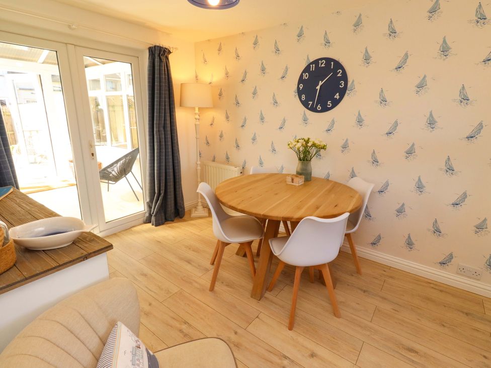 A dining room with a round table and chairs at Dunford Cottage in Bamburgh