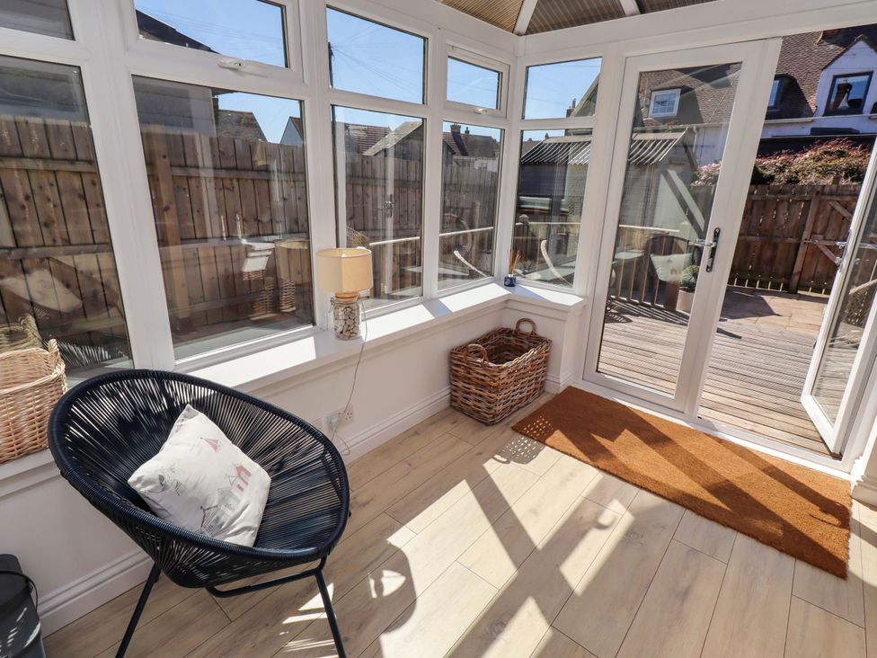 A conservatory with a chair and lamp at Dunford Cottage in Bamburgh