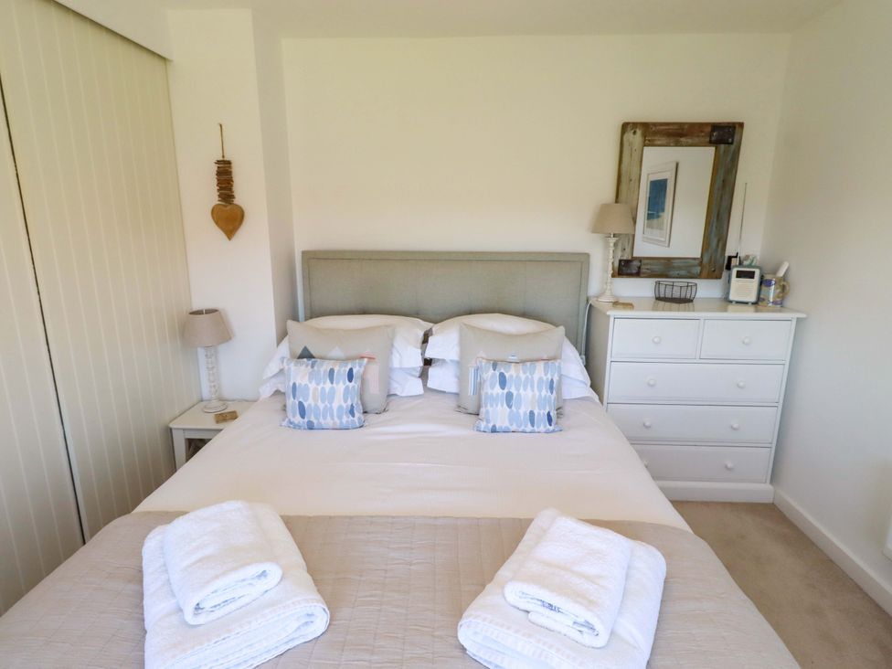 A bedroom with a bed and dresser at Dunford Cottage Bamburgh