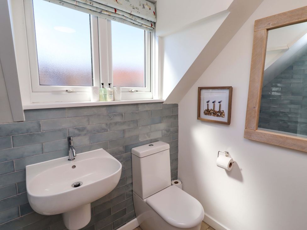 A bathroom featuring a toilet and sink at Dunford Cottage in Bamburgh
