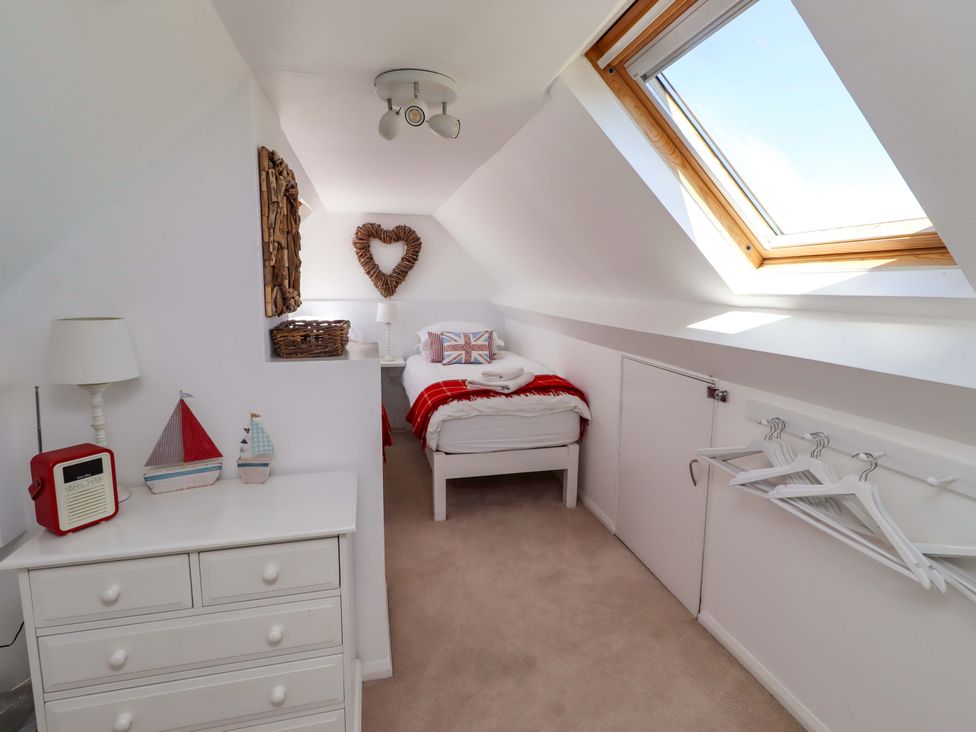 A bedroom with a bed and dresser at Dunford Cottage in Bamburgh