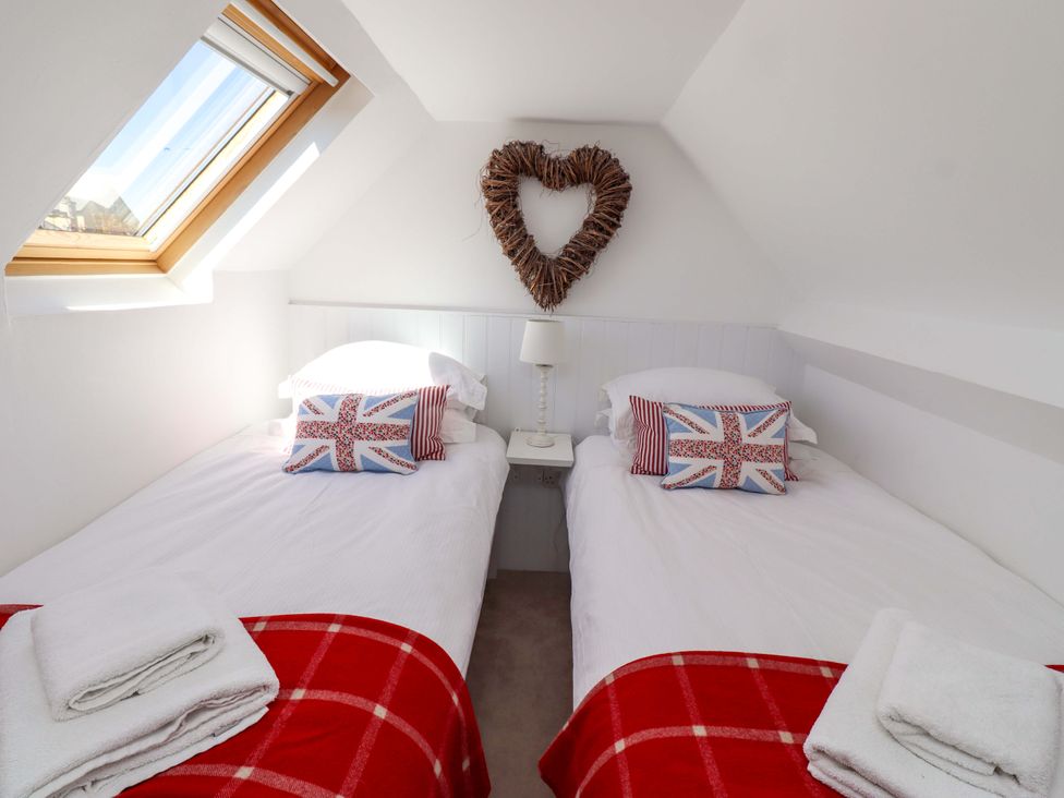 A bedroom with two beds and a heart decoration at Dunford Cottage in Bamburgh