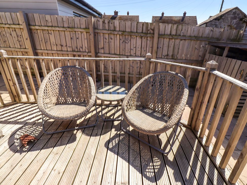Outdoor seating area with two chairs and a table at Dunford Cottage in Bamburgh
