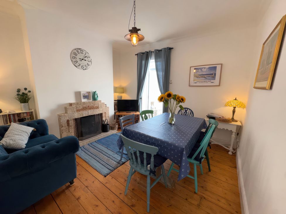A dining room with a table and chairs at Anchor Cottage (Seahouses) in Seahouses