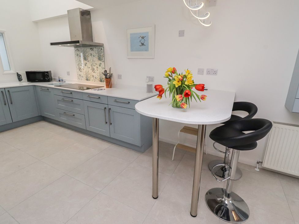 A kitchen with a bar table and chairs at Dell Point Beadnell