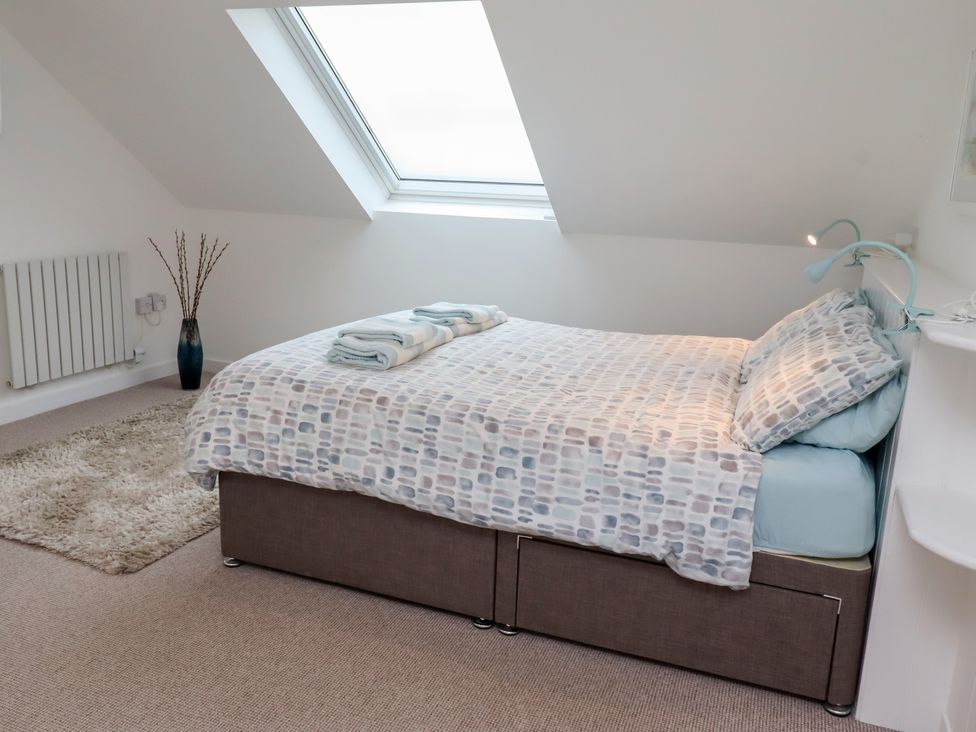 A bedroom with a bed and a window at Dell Point in Beadnell
