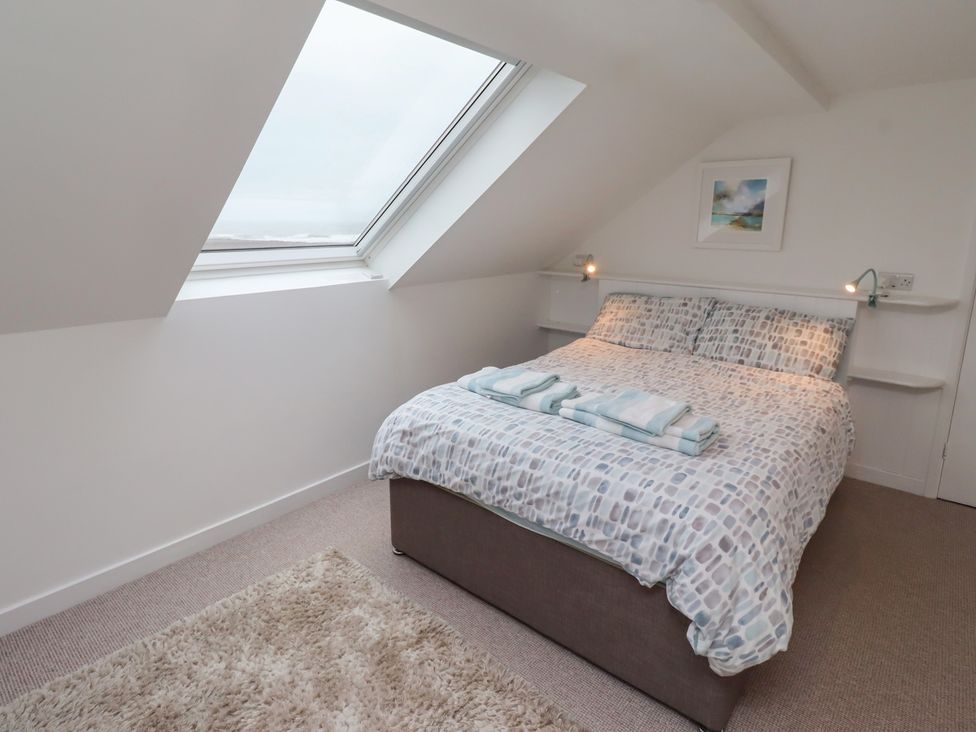 A bedroom with a bed and natural light at Dell Point in Beadnell