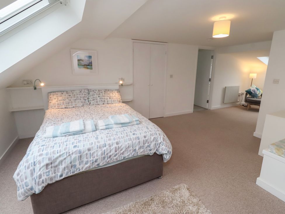 A bedroom with a bed and chair at Dell Point in Beadnell
