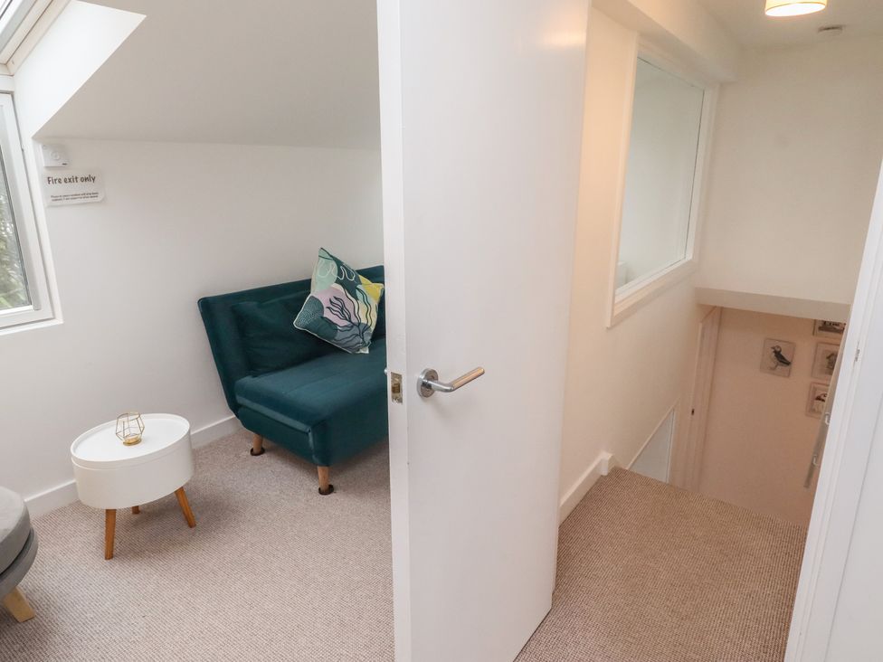 A landing area with a sofa, table, and door at Dell Point in Beadnell