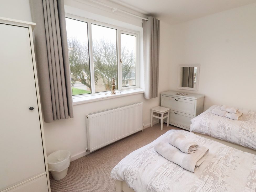 A bedroom with twin beds and a dresser at Dell Point Beadnell
