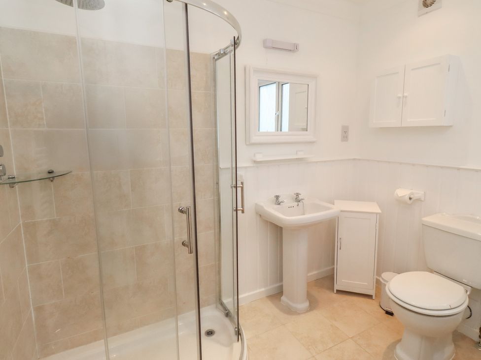 A bathroom with a shower, sink, and toilet at Dell Point in Beadnell