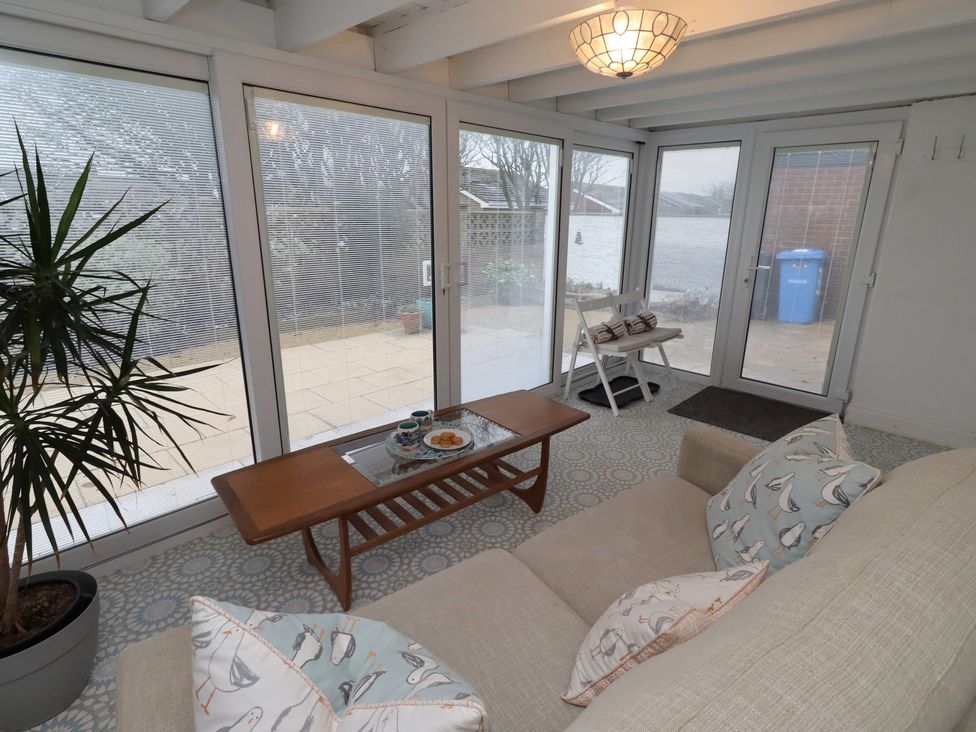 A conservatory with a sofa and coffee table at Dell Point Beadnell