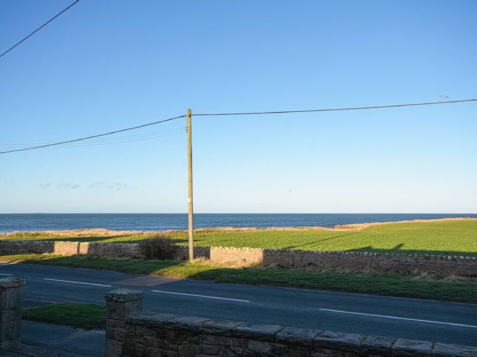 A view of the ocean and grassland from the road at Dell Point in Beadnell