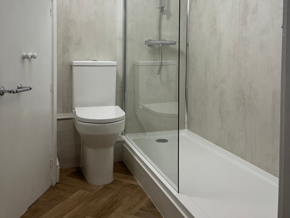 A bathroom with a toilet and shower at Old Bakery No2 Seahouses
