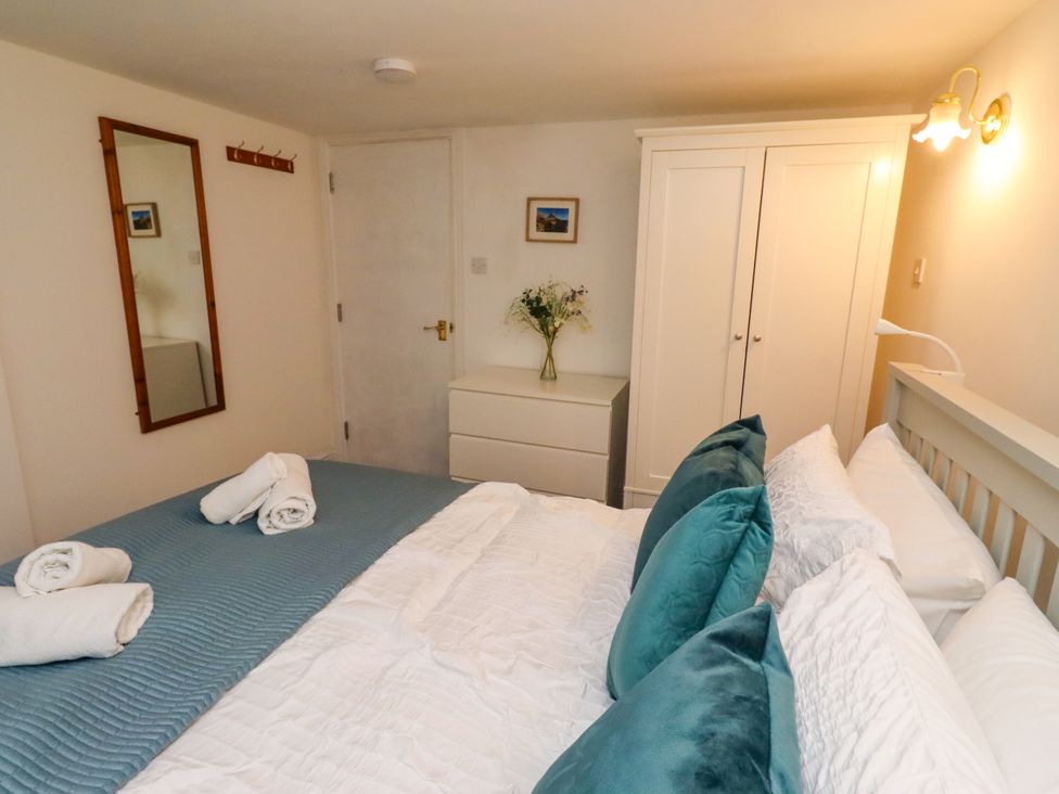 A bedroom with a bed and wardrobe at Old Bakery No2 in Seahouses