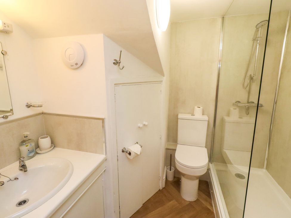 A bathroom with a sink, toilet, and shower at Old Bakery No2 in Seahouses