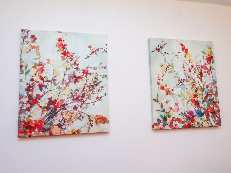 Two abstract flower paintings on a wall at Old Bakery No2 Seahouses