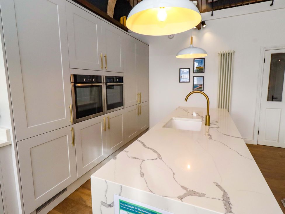 A kitchen with cabinets and an island at Treetops, Alnwick