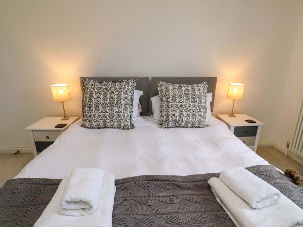 A bedroom with a bed and bedside tables at Treetops, Alnwick