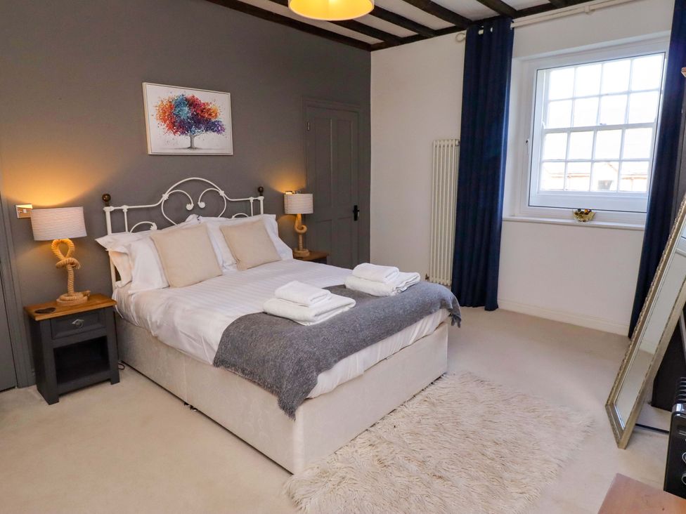 A bedroom with a bed and bedside tables at Treetops, Alnwick