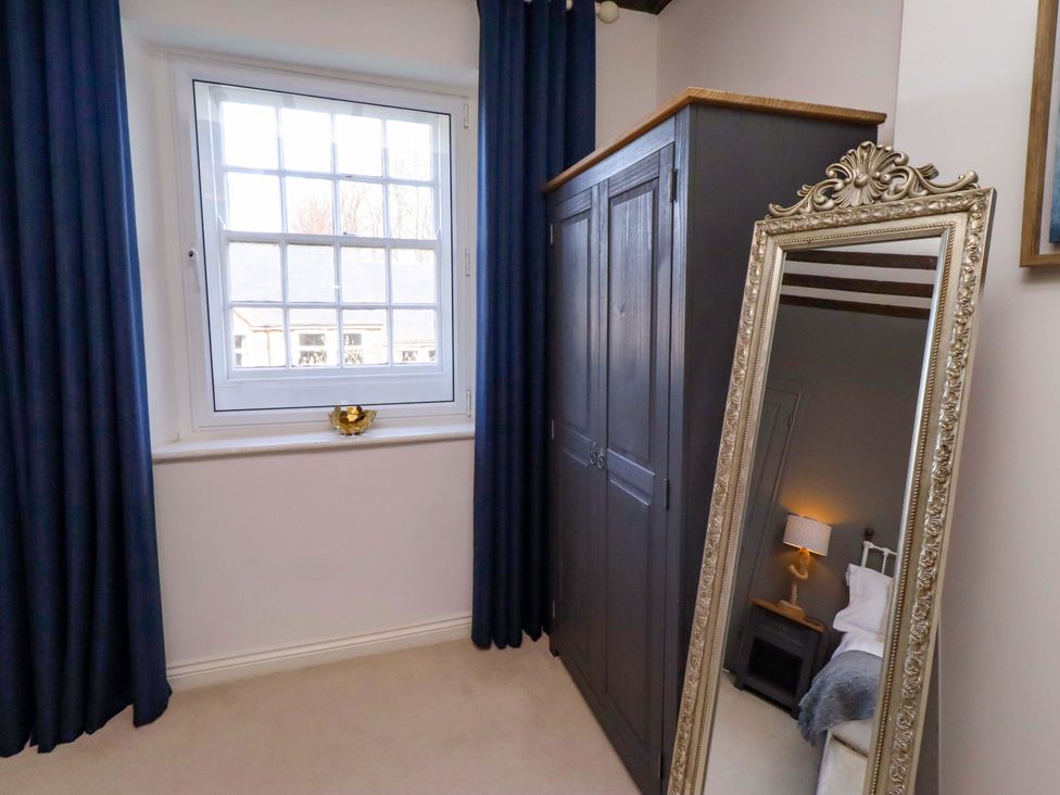 A bedroom with a window and a wardrobe at Treetops, Alnwick