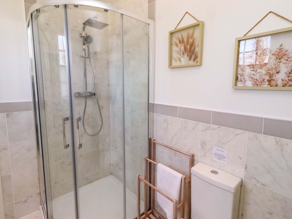 A bathroom with a shower and towel rack at Treetops, Alnwick