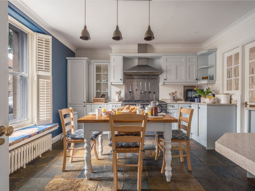 A kitchen with a dining table and chairs at Westhill House in Warkworth
