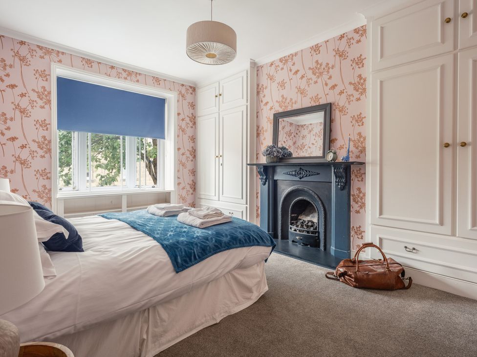 A bedroom with a bed and a fireplace at Westhill House in Warkworth