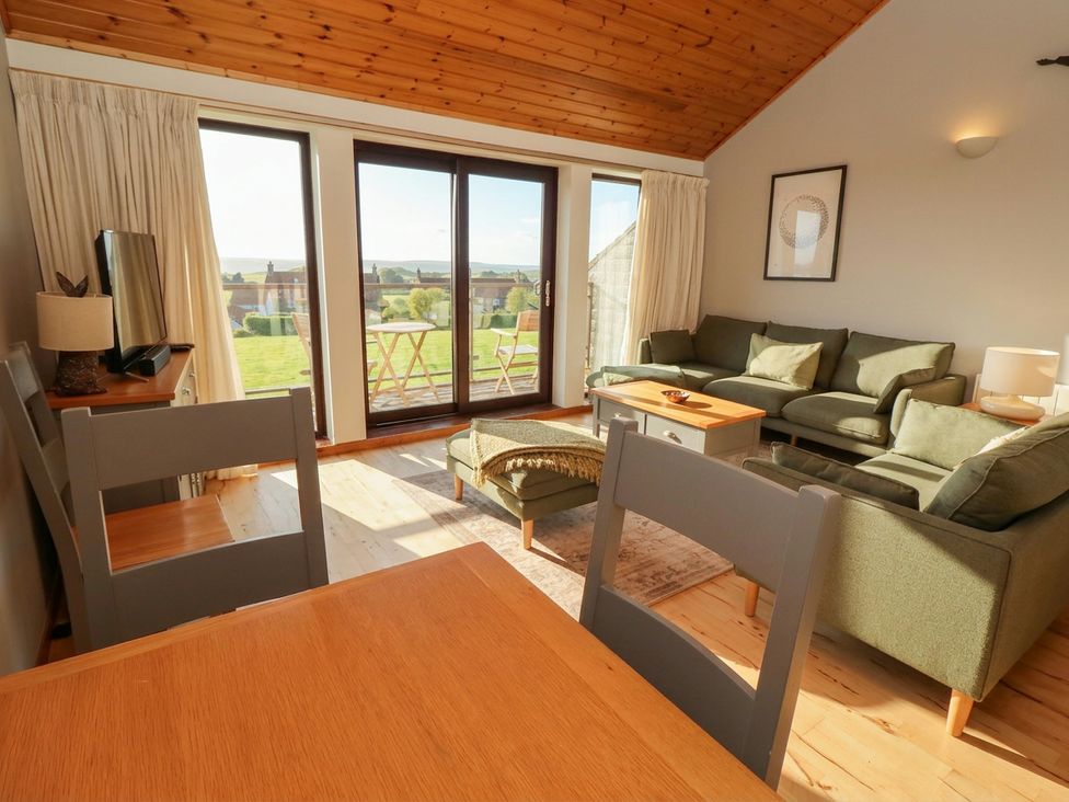 A living room with a sofa and dining table at Links View in Embleton