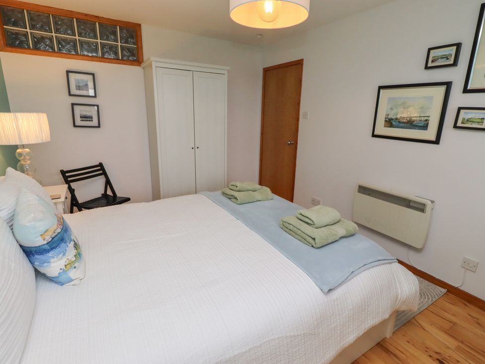 A bedroom with a bed, towels, and a wardrobe at Links View Embleton