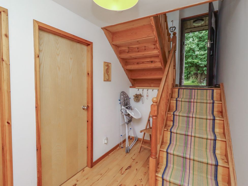 A hallway with a staircase and door at Links View in Embleton