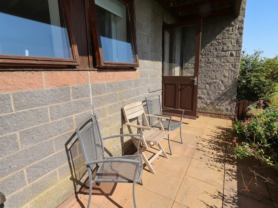 An outdoor area with chairs and a door at Links View in Embleton