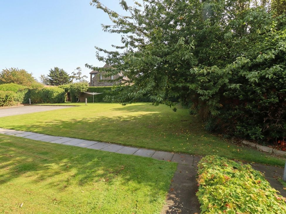 A garden with grass and trees at Links View in Embleton