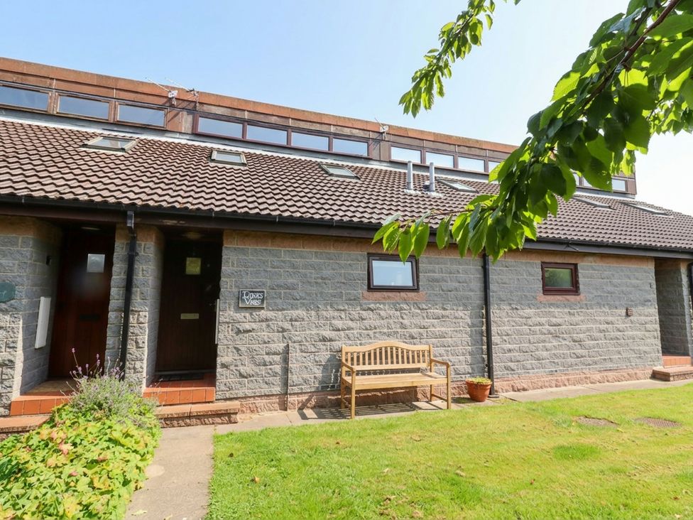 A house exterior with a bench and lawn at Links View in Embleton