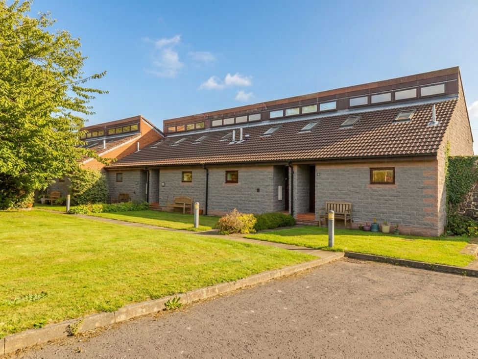 A house with benches and grass at Links View in Embleton