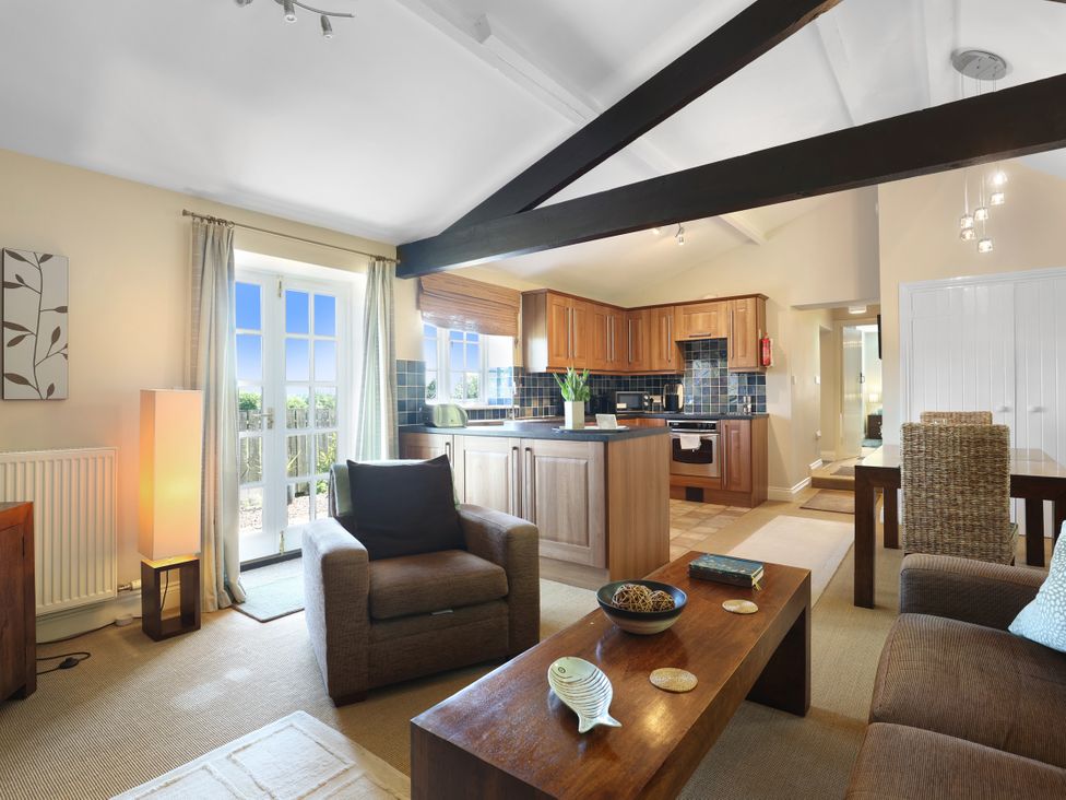 A living room with a sofa and coffee table at Plumtree Cottage in Alnmouth