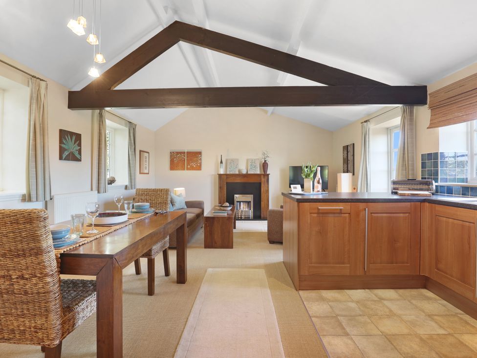 A living room with a dining area and kitchen in Plumtree Cottage Alnmouth