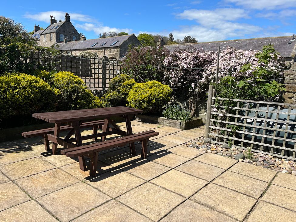 A garden with a table and benches at Beachward in Embleton