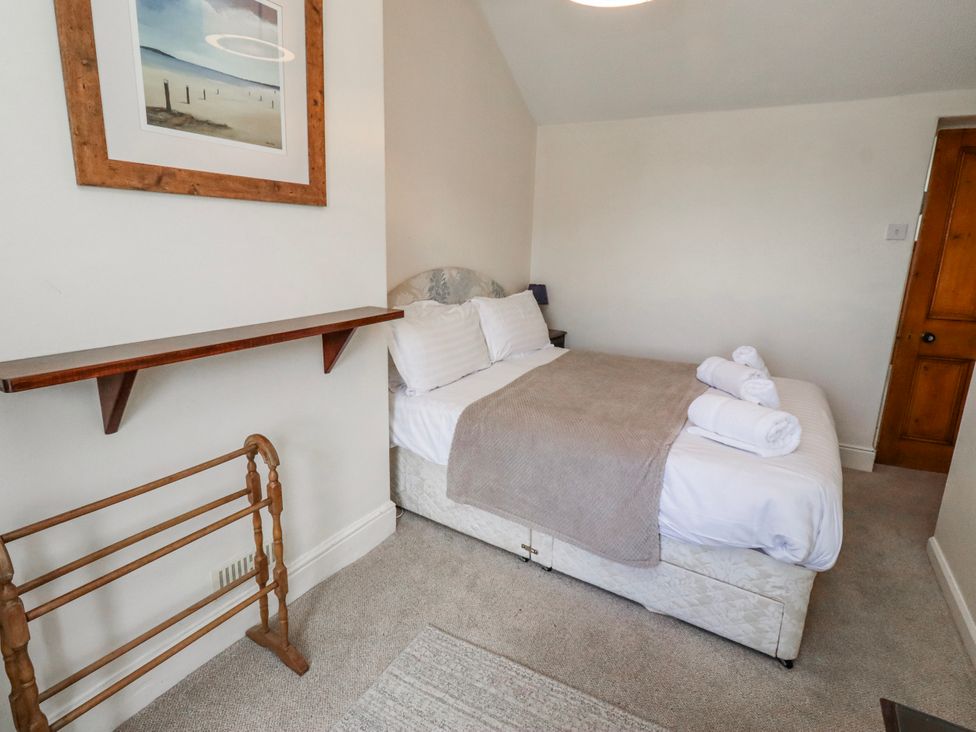 A bedroom with a bed and shelves at Hardys House Alnwick