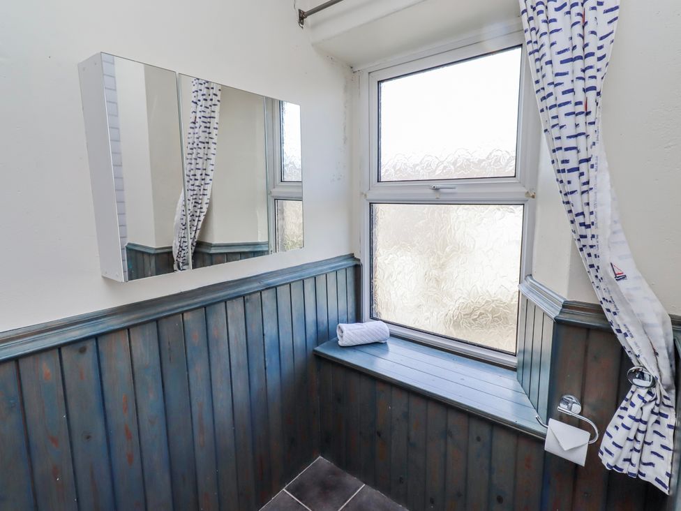 A bathroom with a mirror and window at Hardys House in Alnwick