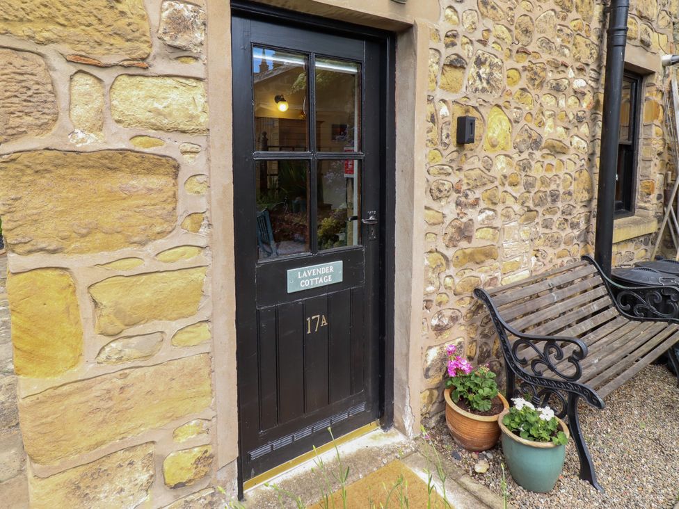 An entrance door with a nameplate and a bench at Lavender Cottage in Alnwick