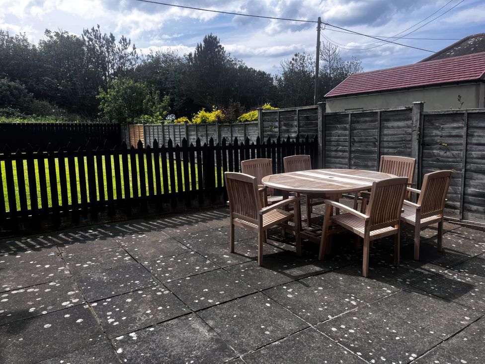 A garden with a wooden table and chairs at Glenavon in Seahouses